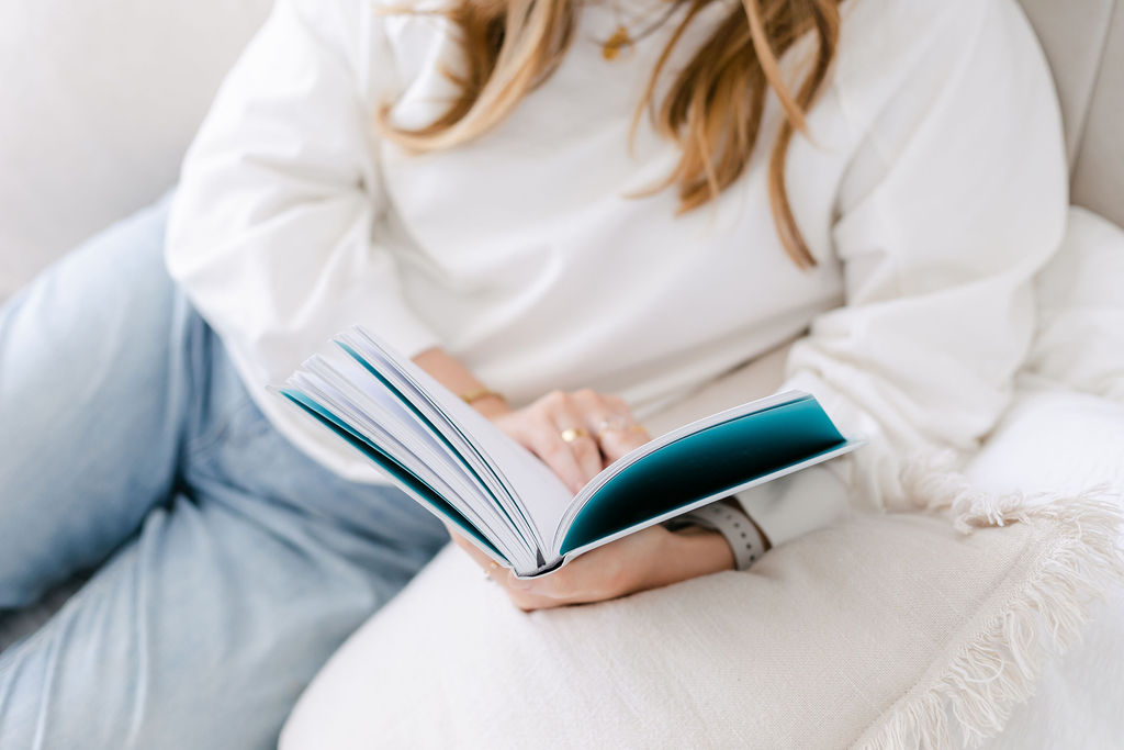 Natalie Englander CBT Therapist reading book on white sofa
